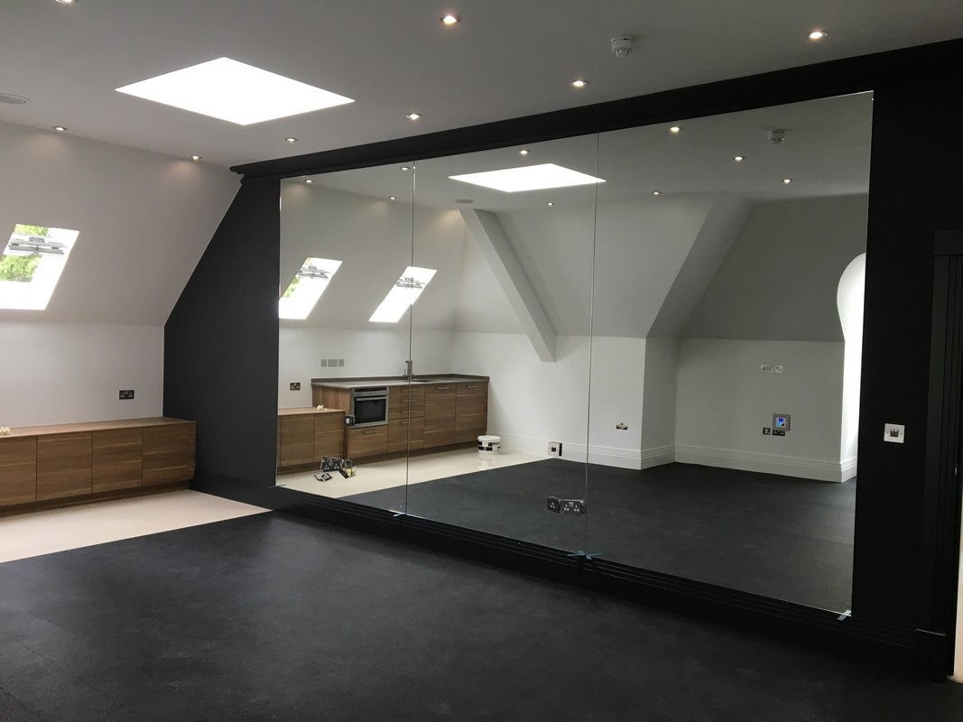 Frameless glass wall dividing loft conversion in Welwyn Garden City